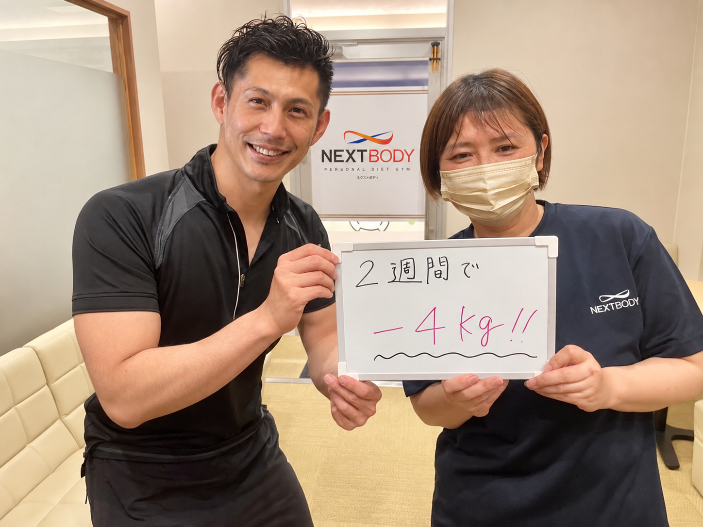 2週間で体重4kg減のボードを持つM様とトレーナー